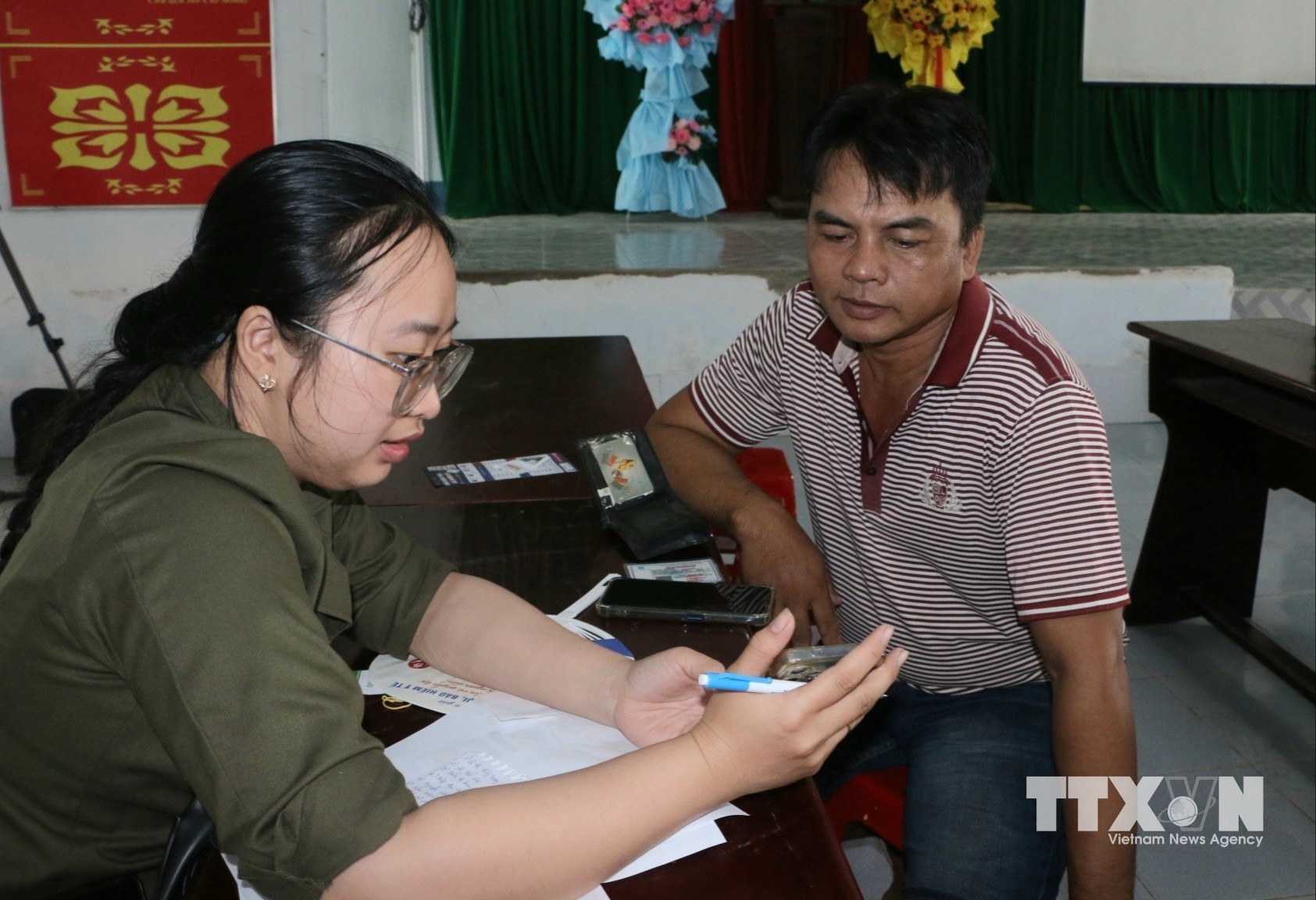 Công an xã, đoàn thể, doanh nghiệp viễn thông, ngân hàng và Tổ Công nghệ số cộng đồng hướng dẫn người dân, góp phần đưa các tiện ích số đến gần hơn với từng hộ dân. (Ảnh: Duy Khương/TTXVN)